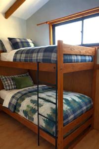 zwei Etagenbetten in einem Zimmer mit Fenster in der Unterkunft Cabaña equipada a 5 minutos de Panguipulli in Huellahue