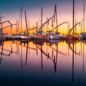 a group of boats docked in a marina at sunset at Studio vue mer & accès direct à la plage in Le Barcarès +7 photos