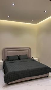 een slaapkamer met een bed in een witte kamer bij Supreme suites in Al Kharj
