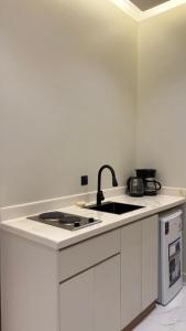 een witte keuken met een spoelbak en een fornuis bij Supreme suites in Al Kharj +3 foto's