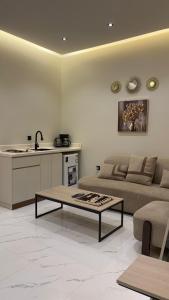 een woonkamer met een bank en een tafel bij Supreme suites in Al Kharj