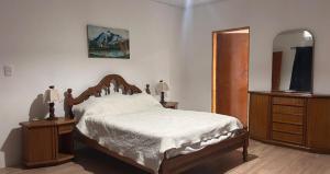 a bedroom with a bed and a dresser and a mirror at Quinta con pileta in Brandsen +33 photos