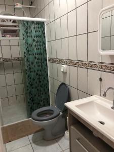 a bathroom with a toilet and a shower and a sink at Kitnet centro de bombinhas in Bombinhas
