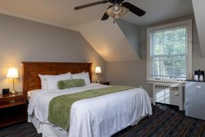una camera da letto con un letto e un ventilatore a soffitto di Sherwood Inn a Port Carling