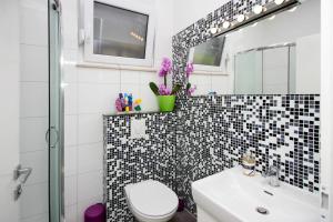 ein Badezimmer mit Toilette, Waschbecken und Spiegel in der Unterkunft Modern Apartment in Trogir - 70 m² - Parking Included in Trogir + 75 Fotos