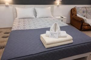 a bedroom with a bed with towels on it at Aerodrom Hotel - Hostel in Almaty +18 photos