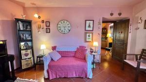 un soggiorno con un divano e un orologio a parete di BARDONECCHIA SCI E RELAX a Bardonecchia