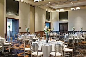 una stanza piena di tavoli e sedie con fiori di Marriott Dallas Fort Worth Westlake a Westlake