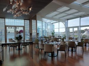 una sala da pranzo con tavoli, sedie e finestre di Vue sur mer 300m de la plage ad Arzon