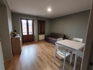 un soggiorno con tavolo, sedie e divano di Favaro di là 2 a Favaro