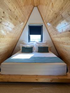 un lit dans une chambre avec un plafond en bois dans l'établissement Feeria Land Aframe, à Radoşi