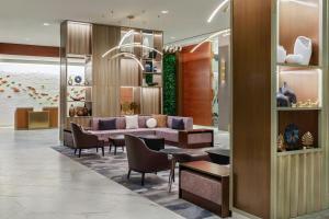 a lobby with a couch and a table and chairs at The Westin Washington Dulles Airport in Herndon