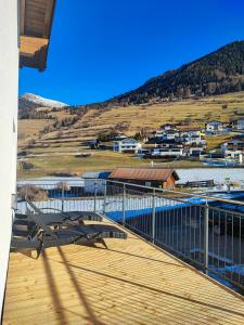 una terrazza in legno con panca in cima a un edificio di das Alpenblick & Outdoor Lodge Nauders a Nauders