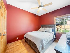 a red bedroom with a bed with a ceiling fan at Beautiful home in Bridgeview! in Bridgeview