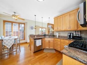 a kitchen with wooden cabinets and a table and a dining room at Beautiful home in Bridgeview! in Bridgeview