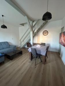 a living room with a table and a blue couch at Au Repaire Maison cosy et terrasse in Troyes