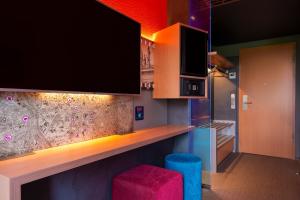 فندق ديزاين + مركز المؤتمرات فينيكي XI. في هانوفر: مطبخ مع بار مع تلفزيون وكرسي
