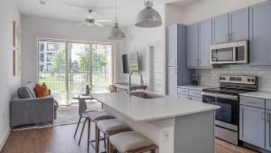 a kitchen with white cabinets and a kitchen island at Landing Beautiful 2BD Pool Yoga Studio in Austin