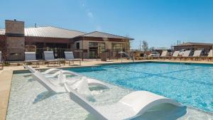a swimming pool with chairs in the water at Landing Beautiful 2BD Pool Yoga Studio in Austin