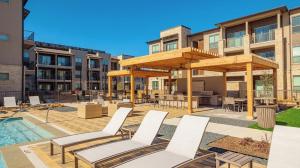 a patio with lounge chairs and a pool in a building at Landing Beautiful 2BD Pool Yoga Studio in Austin