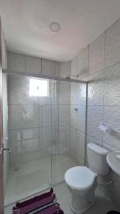 een witte badkamer met toilet en douche bij Triplex Carapibus Beach in João Pessoa +1 foto