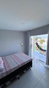 een slaapkamer met een bed met uitzicht op een balkon bij Triplex Carapibus Beach in João Pessoa