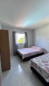 een slaapkamer met twee bedden en een raam bij Triplex Carapibus Beach in João Pessoa
