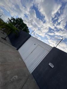 een parkeerplaats met een grote witte muur met een auto bij Triplex Carapibus Beach in João Pessoa