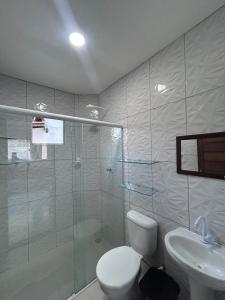 een badkamer met een douche, een toilet en een wastafel bij Triplex Carapibus Beach in João Pessoa