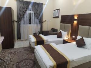 a hotel room with three beds and a couch at شقة مفروشة حائل in Hail