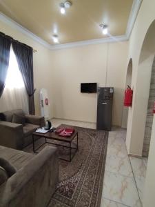 a living room with a couch and a refrigerator at شقة مفروشة حائل in Hail