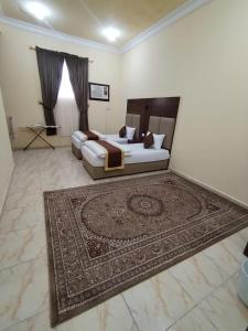 a living room with a bed and a rug at شقة مفروشة حائل in Hail