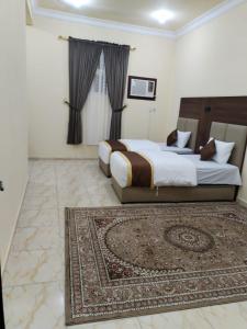 a bedroom with a large bed and a rug at شقة مفروشة حائل in Hail