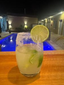 a drink sitting on a table with a lemon slice at Hotel Boutique Porá Iguazú in Puerto Iguazú