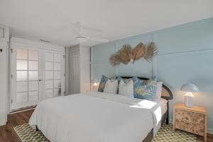 a bedroom with a large white bed with blue walls at The Art Deco Den in Tampa +28 photos
