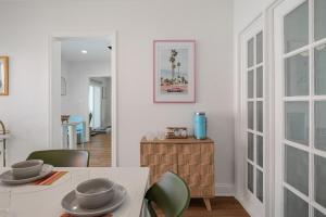 a dining room with a white table and green chairs at The Art Deco Den in Tampa