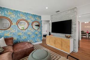 a living room with a couch and a flat screen tv at The Art Deco Den in Tampa