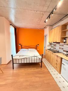 a bedroom with a bed in an orange wall at Cosy City-View Flat in Mtatsminda, flat 7 in Itʼkhvisi
