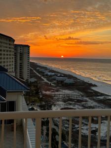 een balkon met uitzicht op het strand bij zonsondergang bij Beachfront Penthouse w Gulf & Bay Views in Gulf Highlands