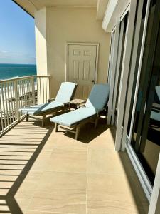2 stoelen en een tafel op een balkon met uitzicht op de oceaan bij Beachfront Penthouse w Gulf & Bay Views in Gulf Highlands