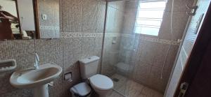 a bathroom with a shower and a toilet and a sink at Apartmento 3 in Santa Vitória do Palmar