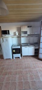 a kitchen with white appliances and a tile floor at Apartmento 3 in Santa Vitória do Palmar