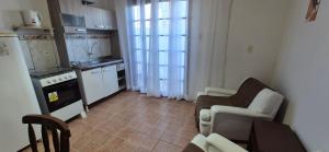 a living room with a table and chairs and a kitchen at Apartmento 3 in Santa Vitória do Palmar +5 photos