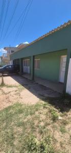 a green house with a car parked in front of it at Apartmento 3 in Santa Vitória do Palmar