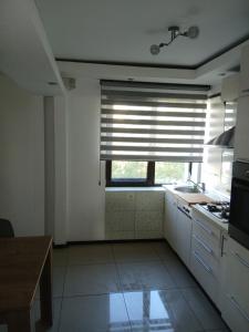 una cucina con finestra, lavandino e piano cottura di Central suite a Piteşti 1 altra foto