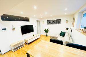 a living room with a couch and a flat screen tv at 1,5-Zimmer, Top ausgestattet, 4 Pers, Souterrain, Self Check-in, Parkplatz, Netflix & Amazon Prime in Flintsbach