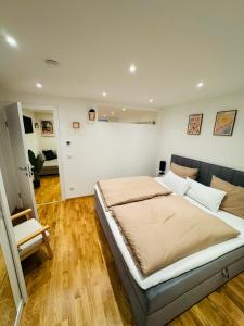 ein Schlafzimmer mit einem großen Bett und einem Stuhl in der Unterkunft 1,5-Zimmer, Top ausgestattet, 4 Pers, Souterrain, Self Check-in, Parkplatz, Netflix & Amazon Prime in Flintsbach