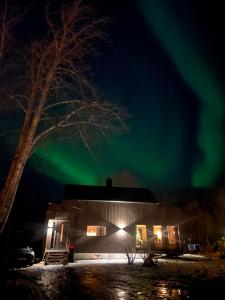 an image of a house with the aurora in the sky at Exclusive Cabin with Sauna in Fossmo