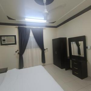 a bedroom with a bed and a dresser and a mirror at شقة مفروشة بتبوك in Tabuk
