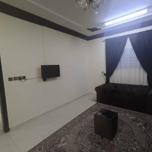 a room with a couch and a tv on a wall at شقة مفروشة بتبوك in Tabuk